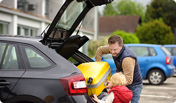 a person and a child with a car with a yellow object on top