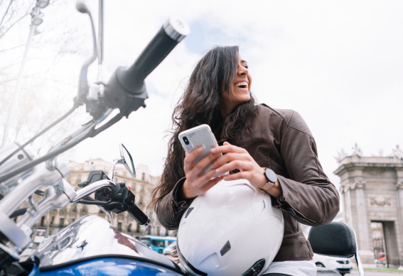 a woman taking a picture of a man on a motorcycle