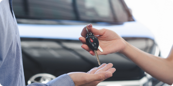 a person handing car keys to another person