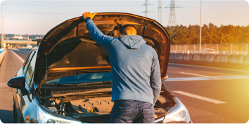 a man looking under the hood of a car