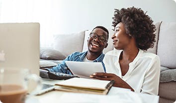 a man and a woman smiling at each other and going over some papers
