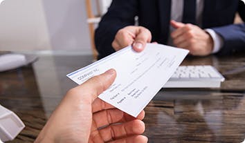 A person handing a check to another person
