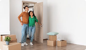 A man and a woman standing in a room with boxes