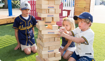 a group of kids playing with a stack of wood blocks