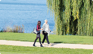 a man and woman walking on a path by a body of water