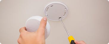 A person working on a smoke alarm