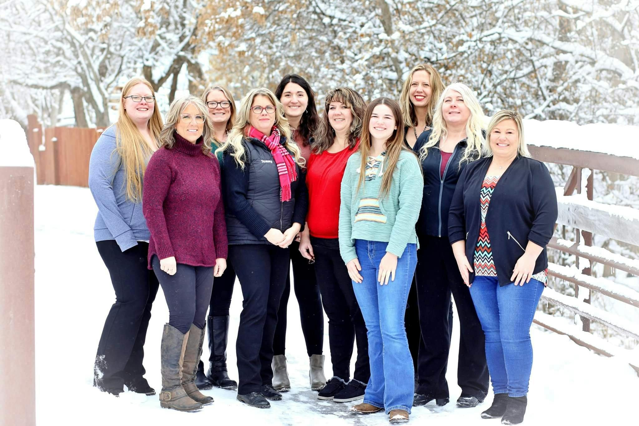 a group of women posing for a photo in the snow