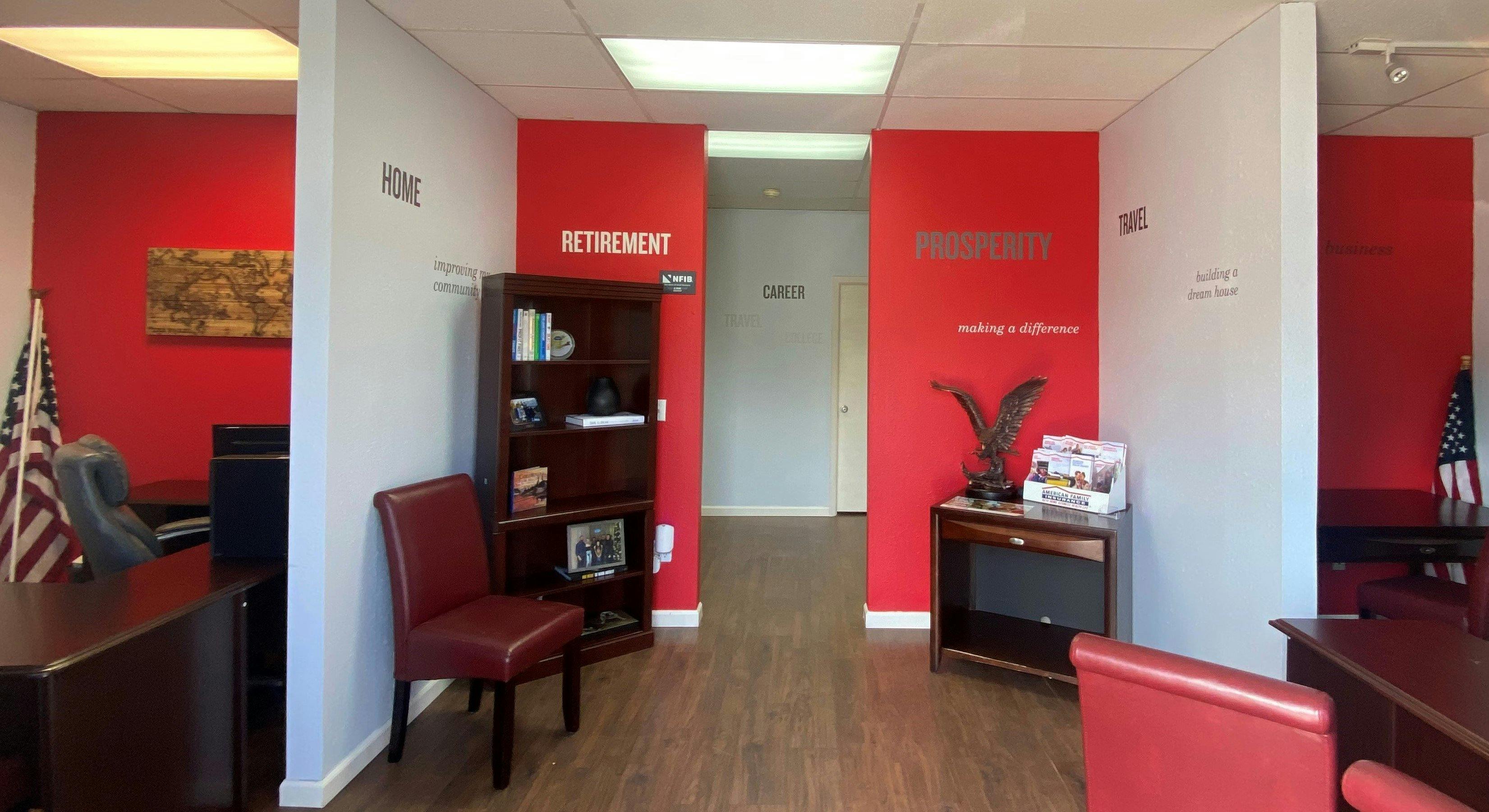 a room with red walls and a desk with a chair and a red wall with a red sign