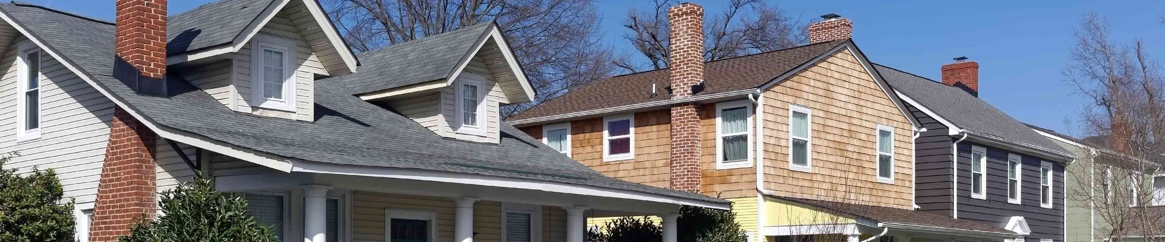 A row of houses with roofs vulnerable to roof leaks.