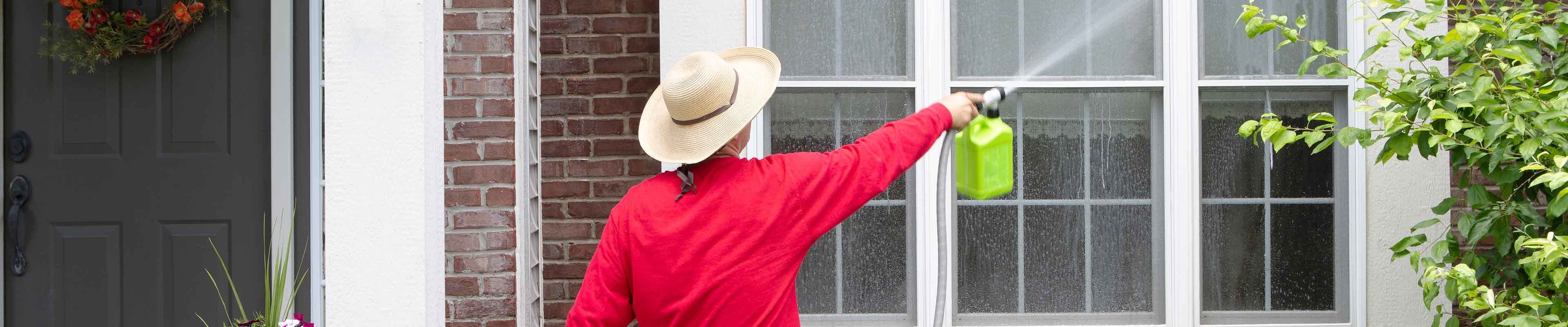 Man spring cleaning the exterior of home.