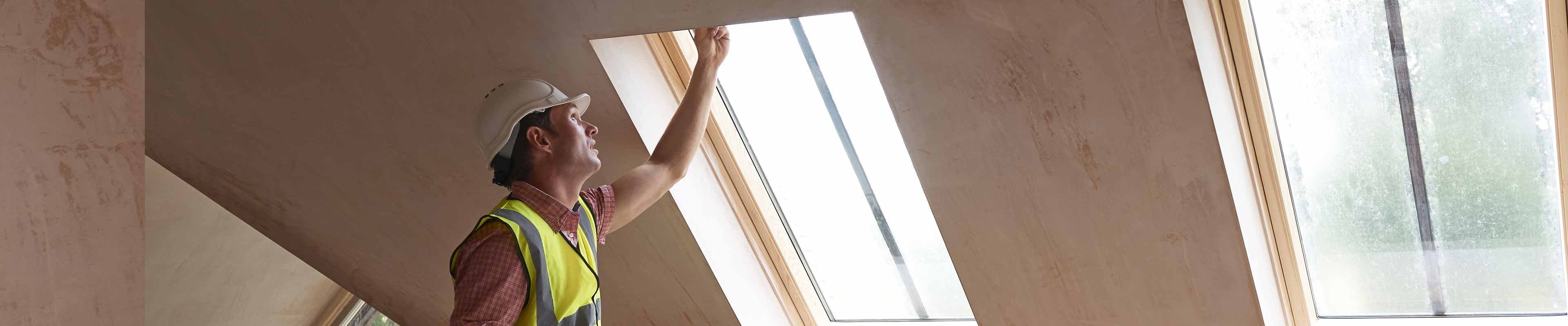 Image of a home inspector checking out a skylight window.