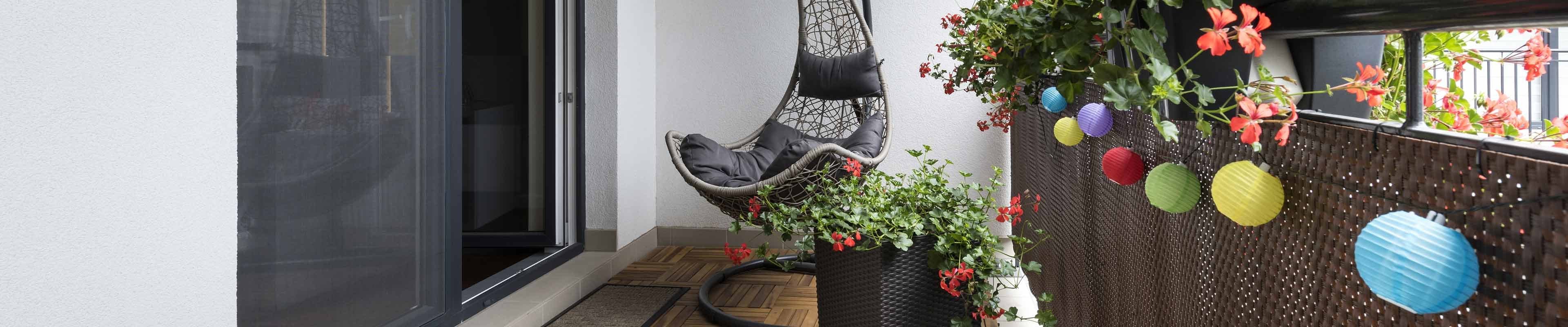 An apartment balcony decorated with plants and other colorful items.