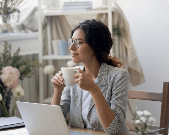 Woman enjoying a break at her desk in front of her laptop.