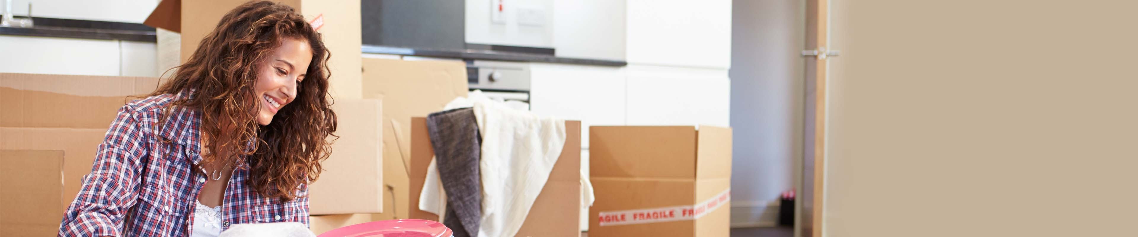 Young woman packing moving boxes