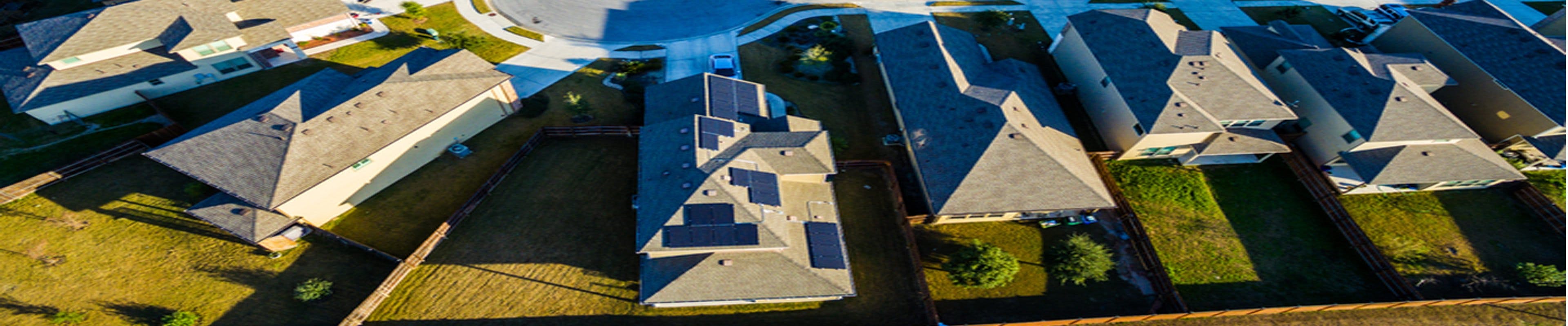 aerial view of a neighborhood with solar panels on roofs