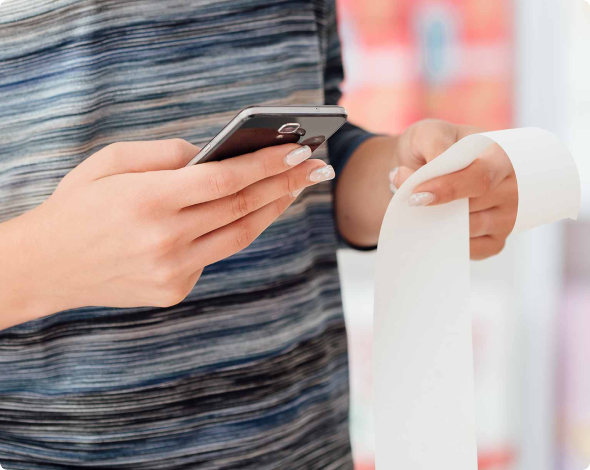 a person holding their phone and a receipt