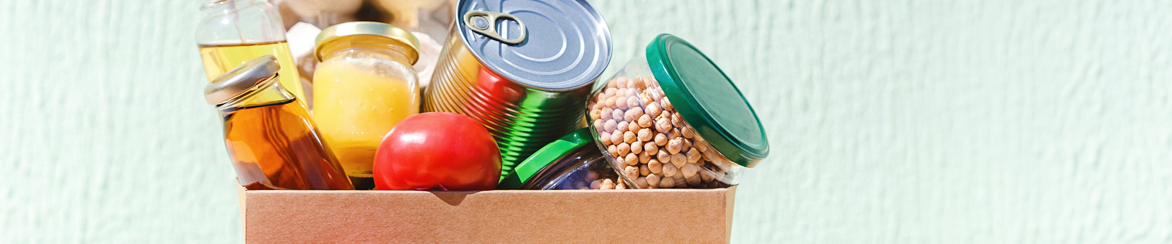 Various types of canned food and vegetables in a box