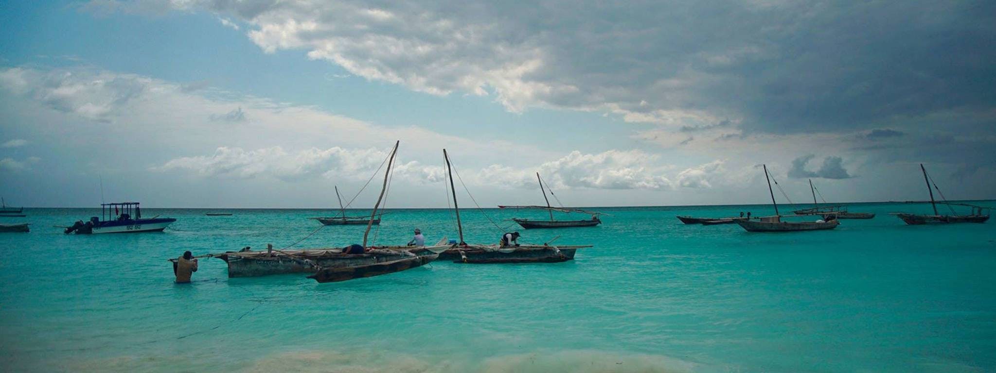 A header photo showing several small boats floating near the shoreline