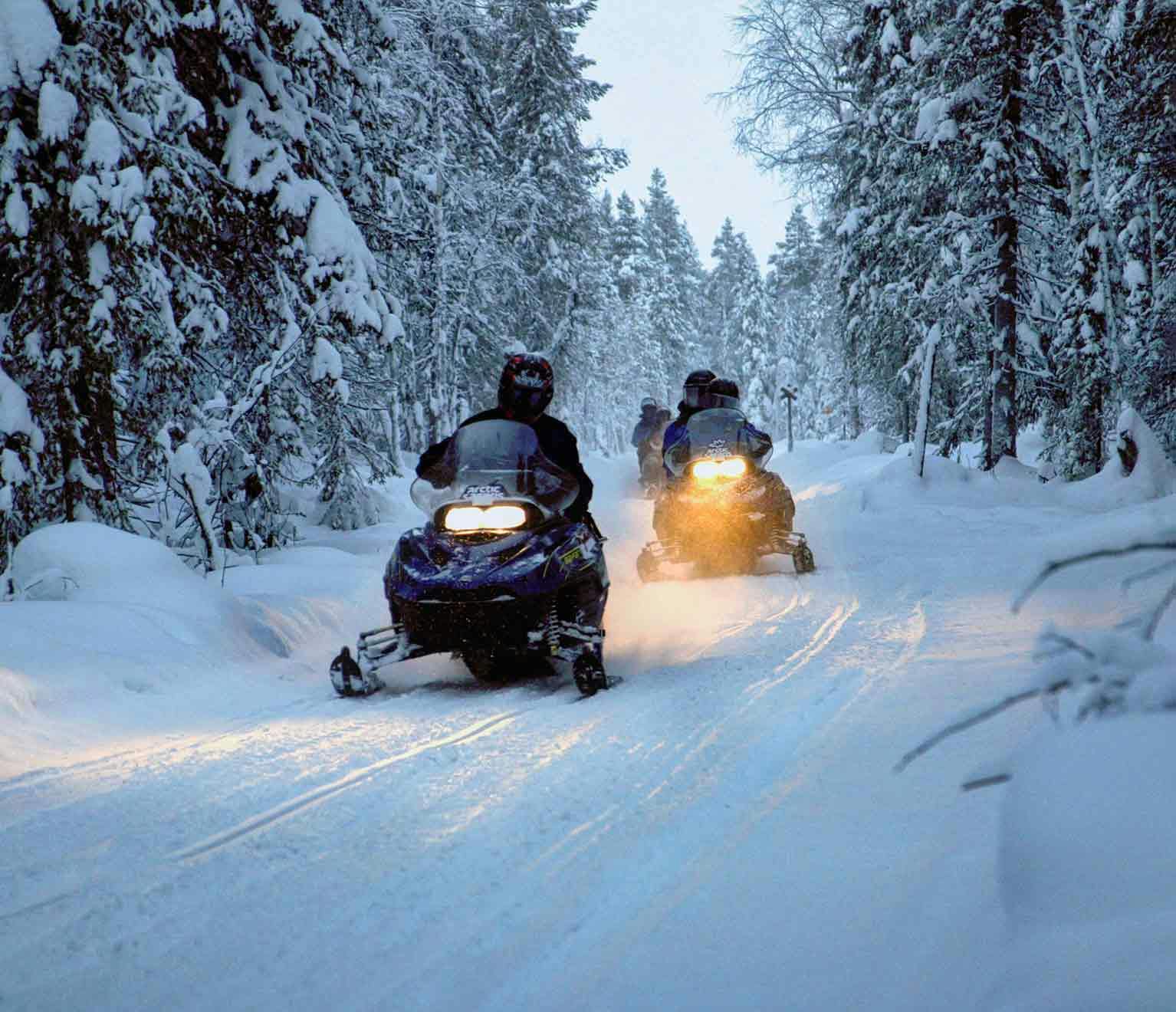 Snowmobile ride at night on a trail during snow