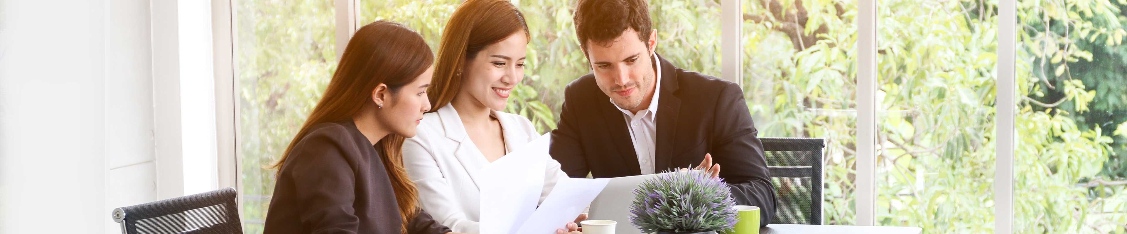 Image of a couple looking at retirement documents with a financial analyst.