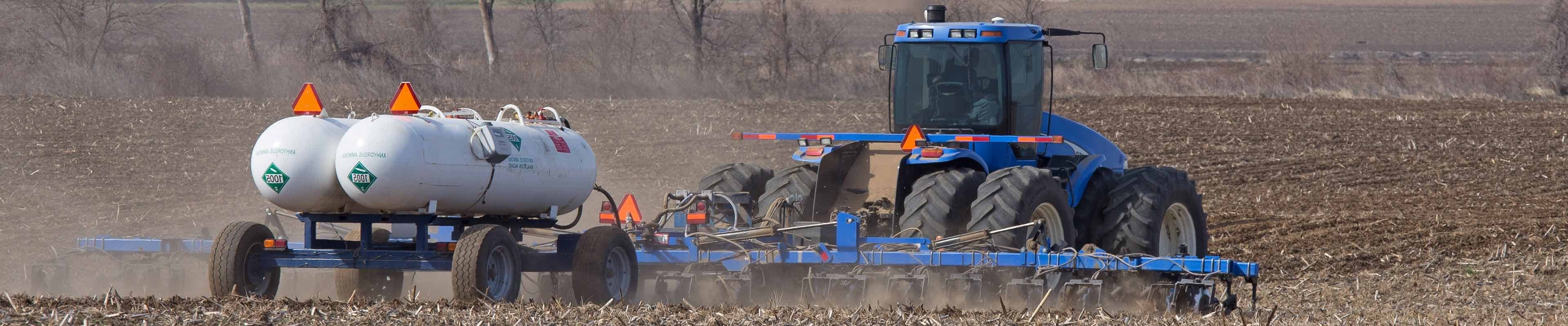 Image of a tractor spraying anhydrous ammonia (NH3) on to a field. 