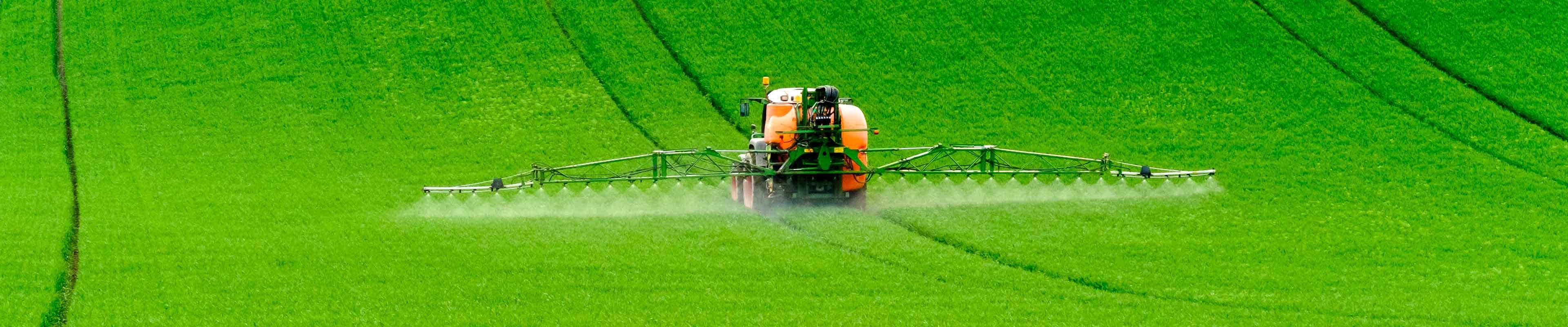 Image of a pesticide spraying  farm implement spraying crops.