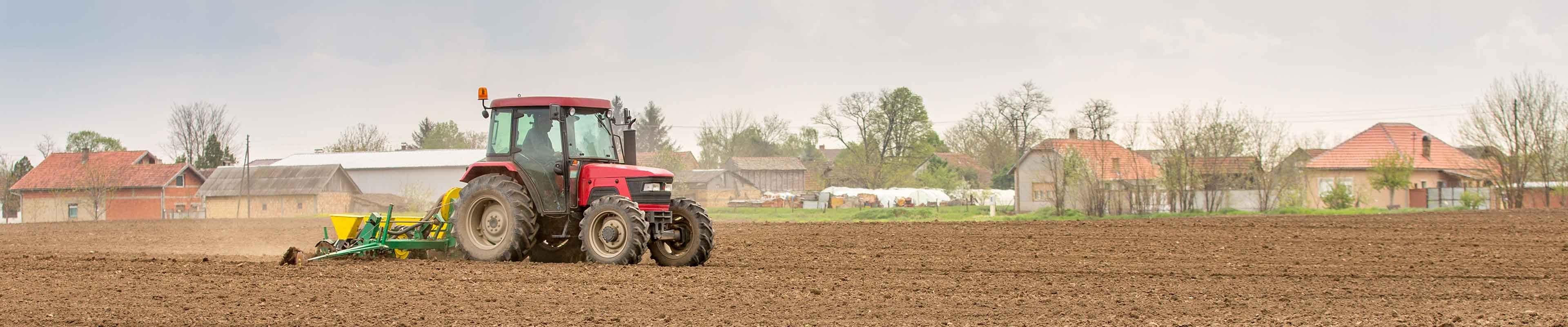 A tractor equipped with a rollover protection structure drives across a field.