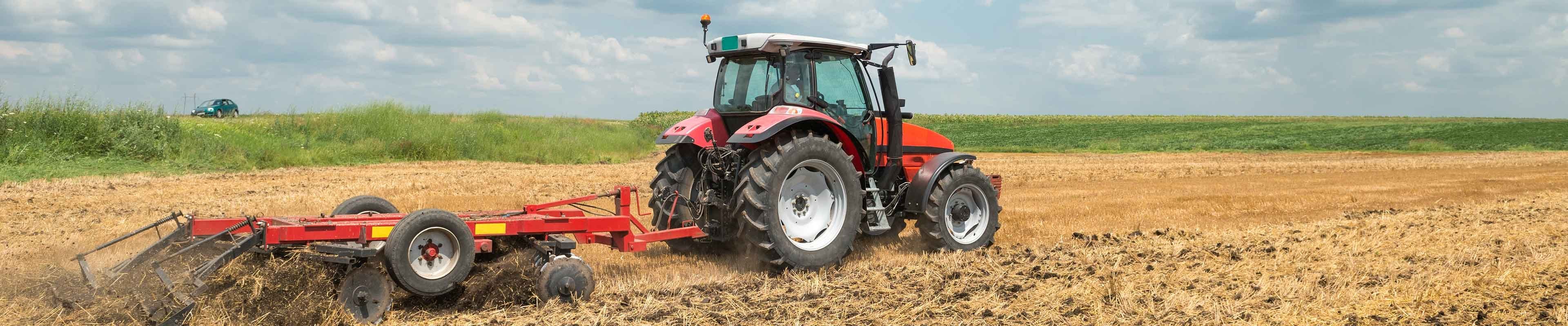 Image of a tractor safely tilling a field.