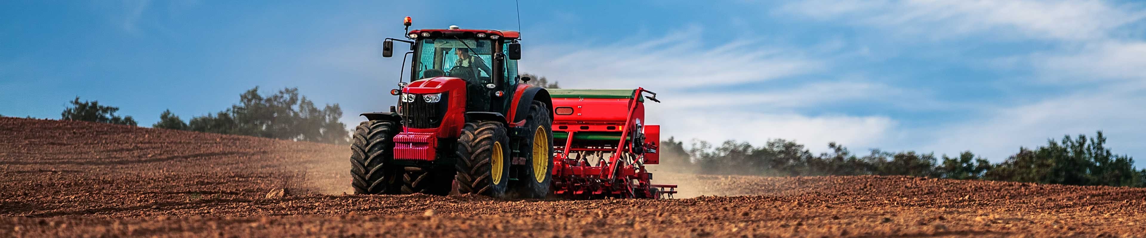 Image of a tractor and seeder rolling through an un-planted field.