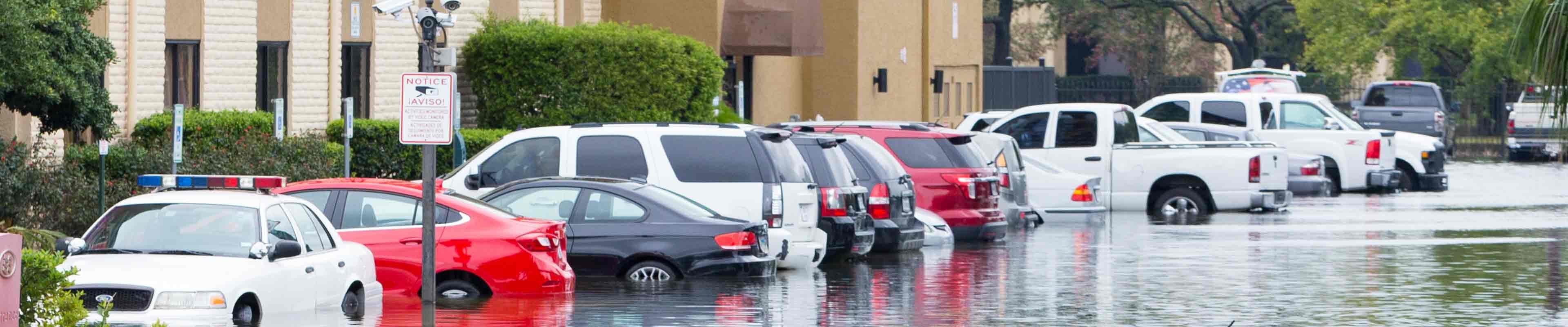 Image of parked cars flooded in a lot.