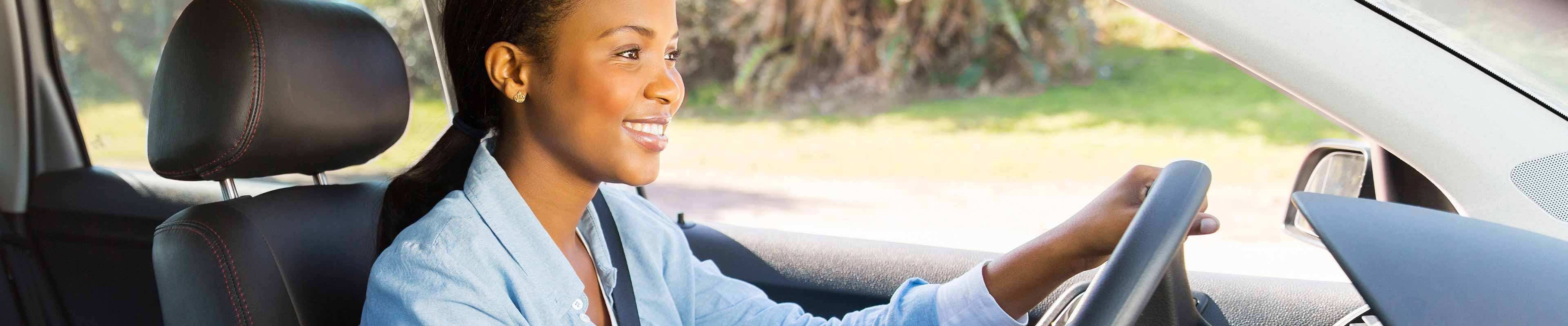 A woman driving a car safely and avoiding distracted driving.