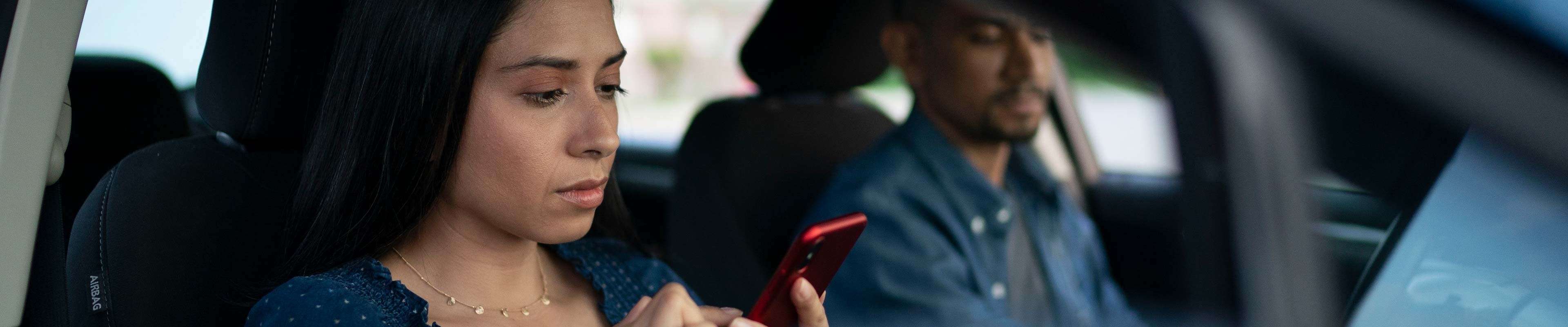 Lady looking at her phone buckled up in the front Passenger seat Web