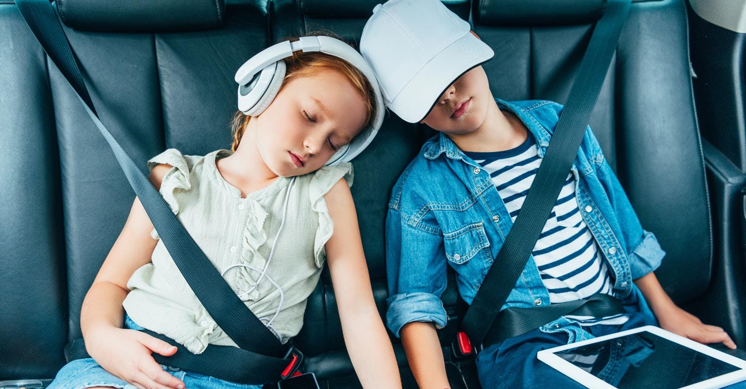 siblings in the back seat of a car sleeping