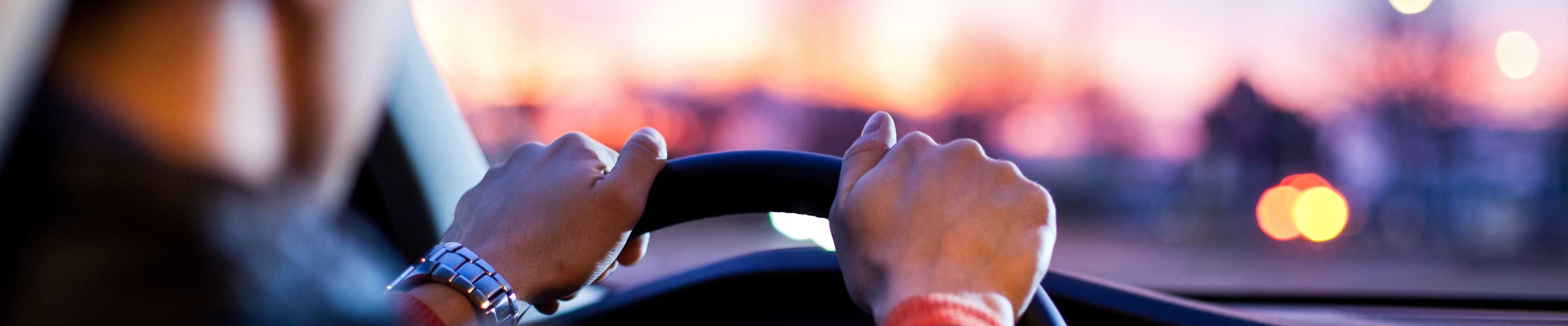 close up shot of hands on a steering wheel