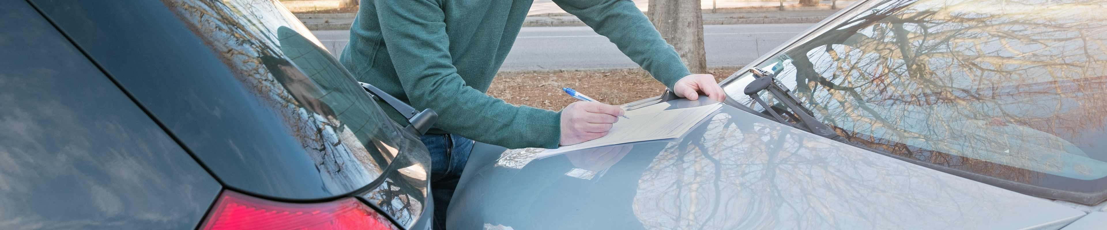 Man filling out information after being in a car accident
