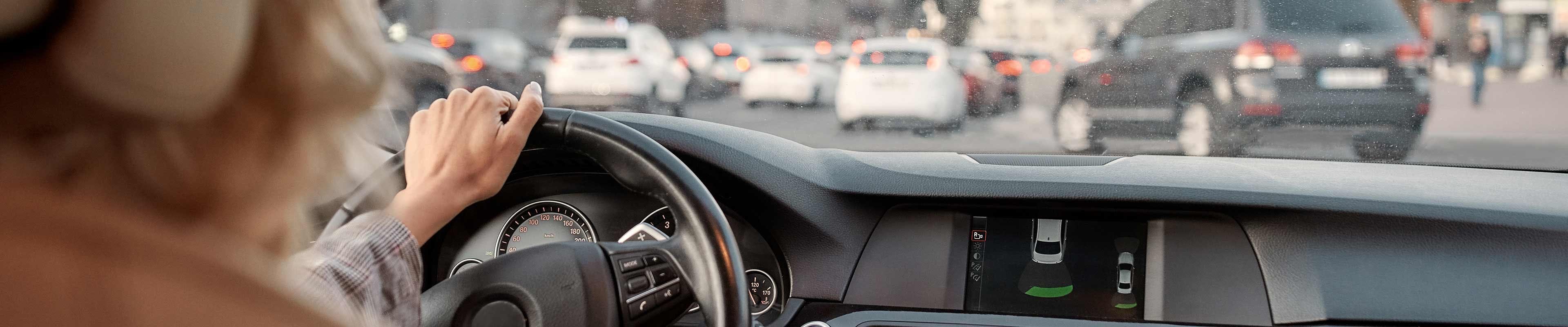 Image of a driver navigating her car through traffic.