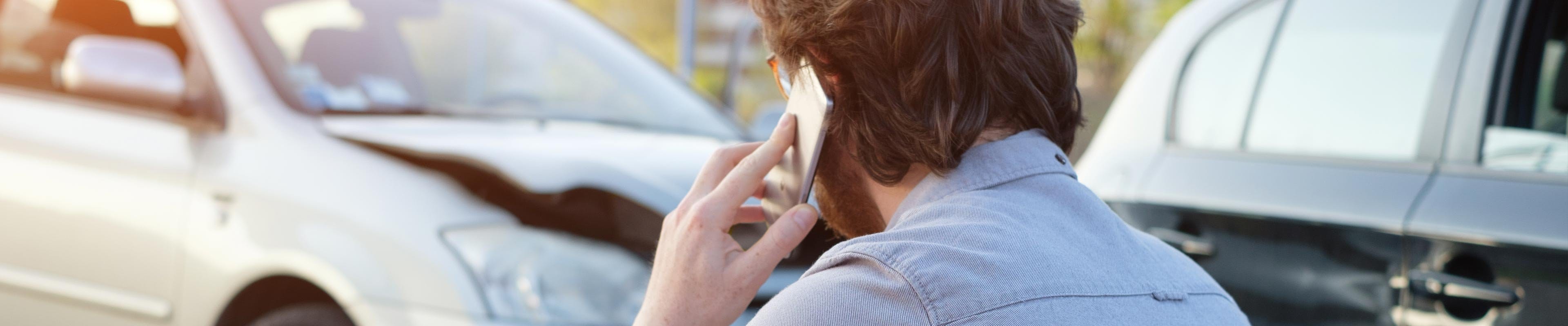Man on cellphone calling about insurance after an accident