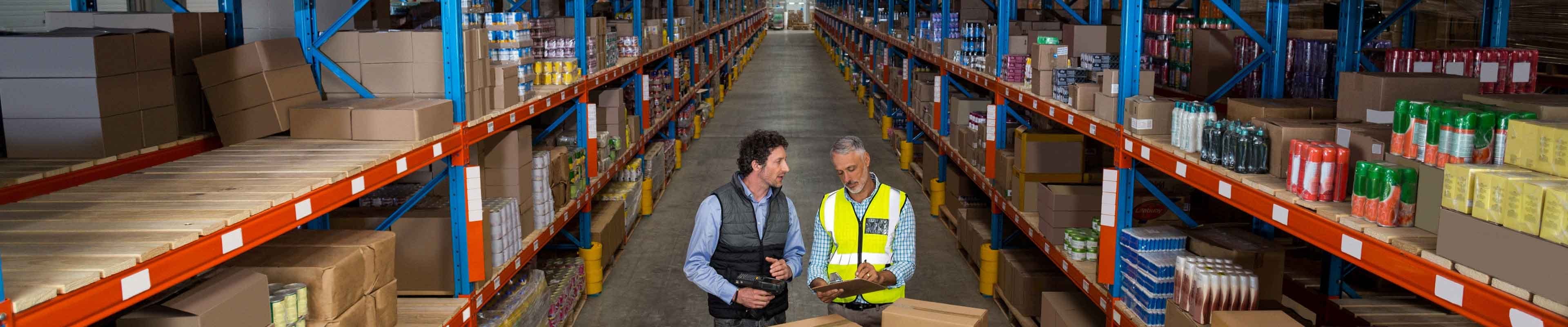 Image of a workplace incident and safety administrator interviewing an employee in a warehouse.