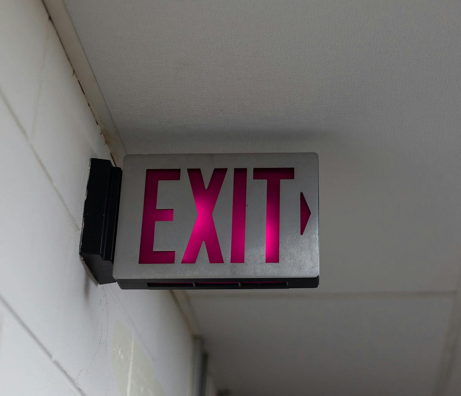 Image of  an emergency exit sign in an apartment building's hallway.