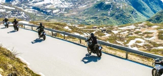 a group of people riding motorcycles on a road