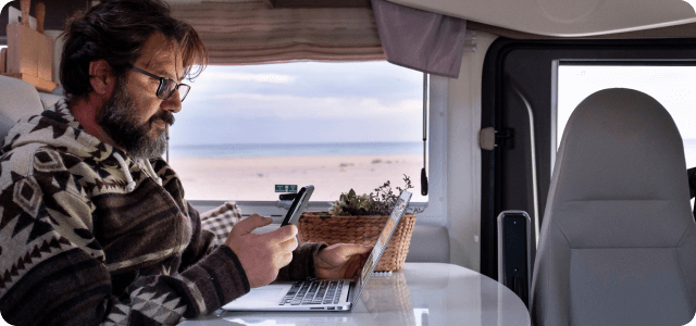 A man working from his laptop inside of an RV