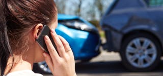 Woman talking on a phone after a car accident