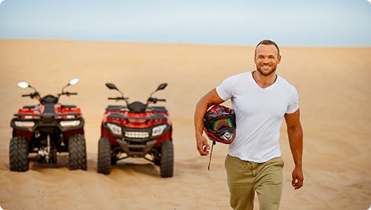 a man standing in front of a row of atvs