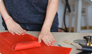 a person's hands on a red cutting board