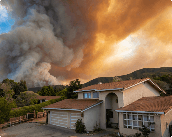House with a looming wildfire in the background.